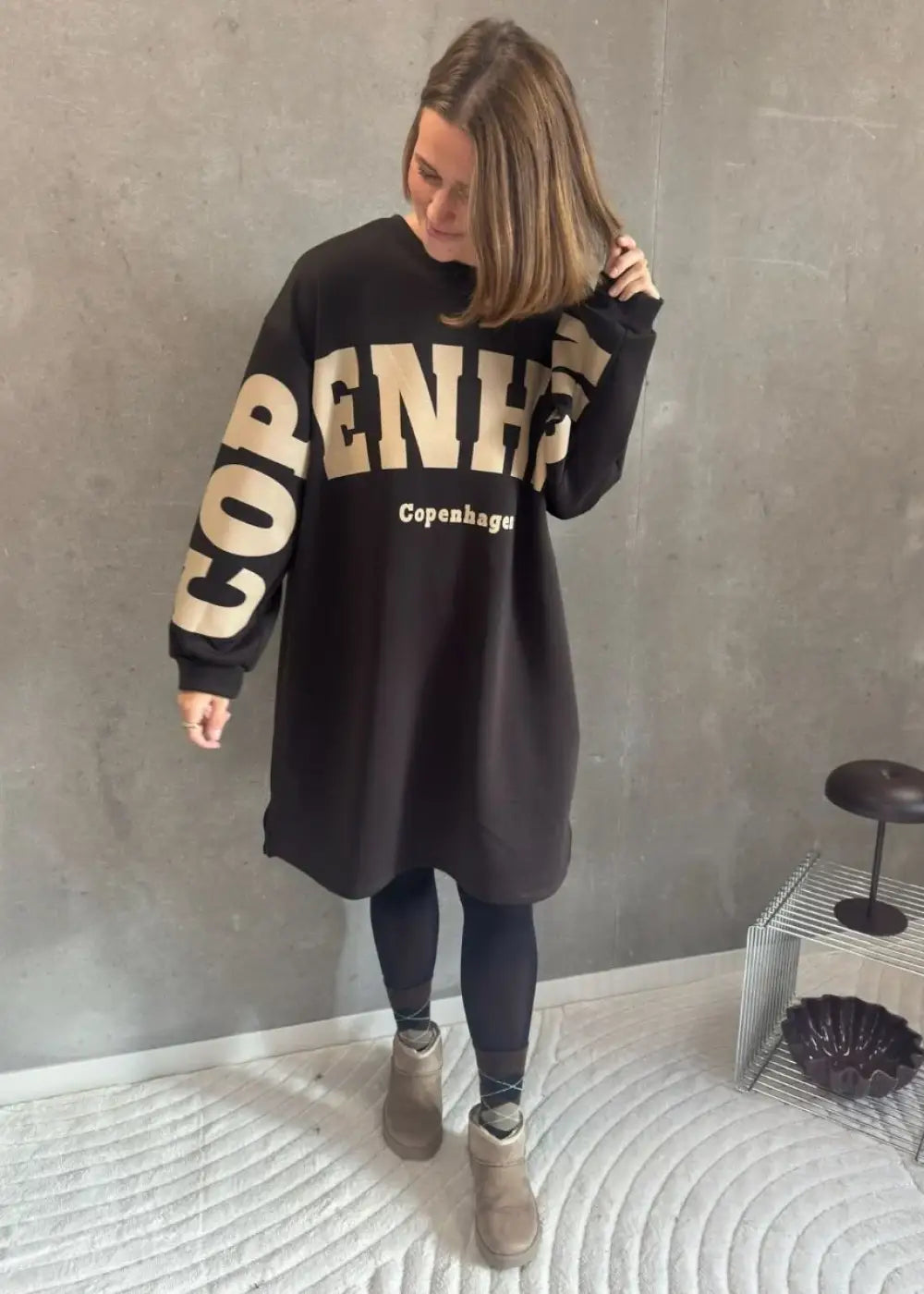 Ruskea oversized-collegemekko, jossa pehmeä joustava materiaali, Copenhagen-tekstiprintti, pitkät hihat ja lyhyet sivuhalkiot helmassa