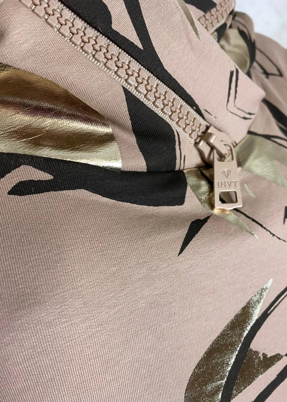 Beige-musta collegehuppari hurmaa abstraktilla printillä ja kultaisilla yksityiskohdilla. Ihastu näyttävään tyyliin ja tilaa omasi!